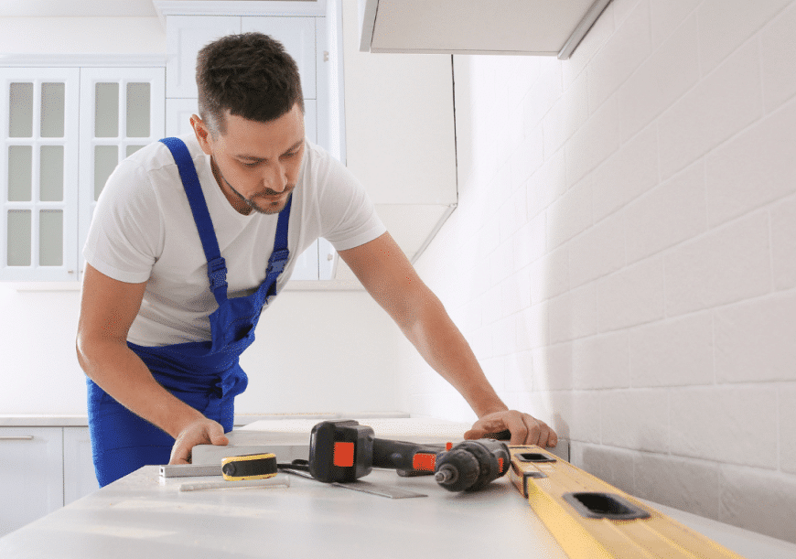 A guy is installing a white countertop, countertop installation.