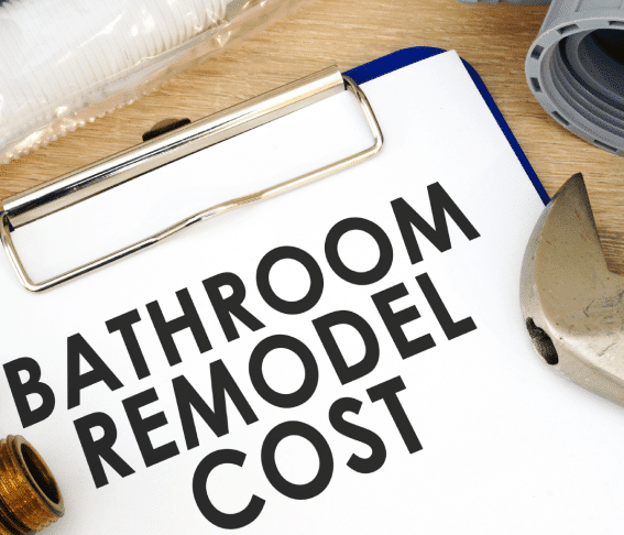 Clipboard with 'BATHROOM REMODEL COST' text, plumbing parts, and tools, indicating expenses. Cost of Bathroom Remodel.