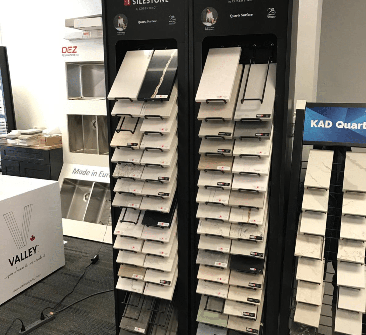 Various quartz countertop samples displayed in a showroom, highlighting a range of colors and patterns for kitchen design.