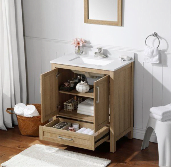 an oak single sink bathroom vanity with two open cabinet doors and a drawer, showcasing organized storage in a bright bathroom.