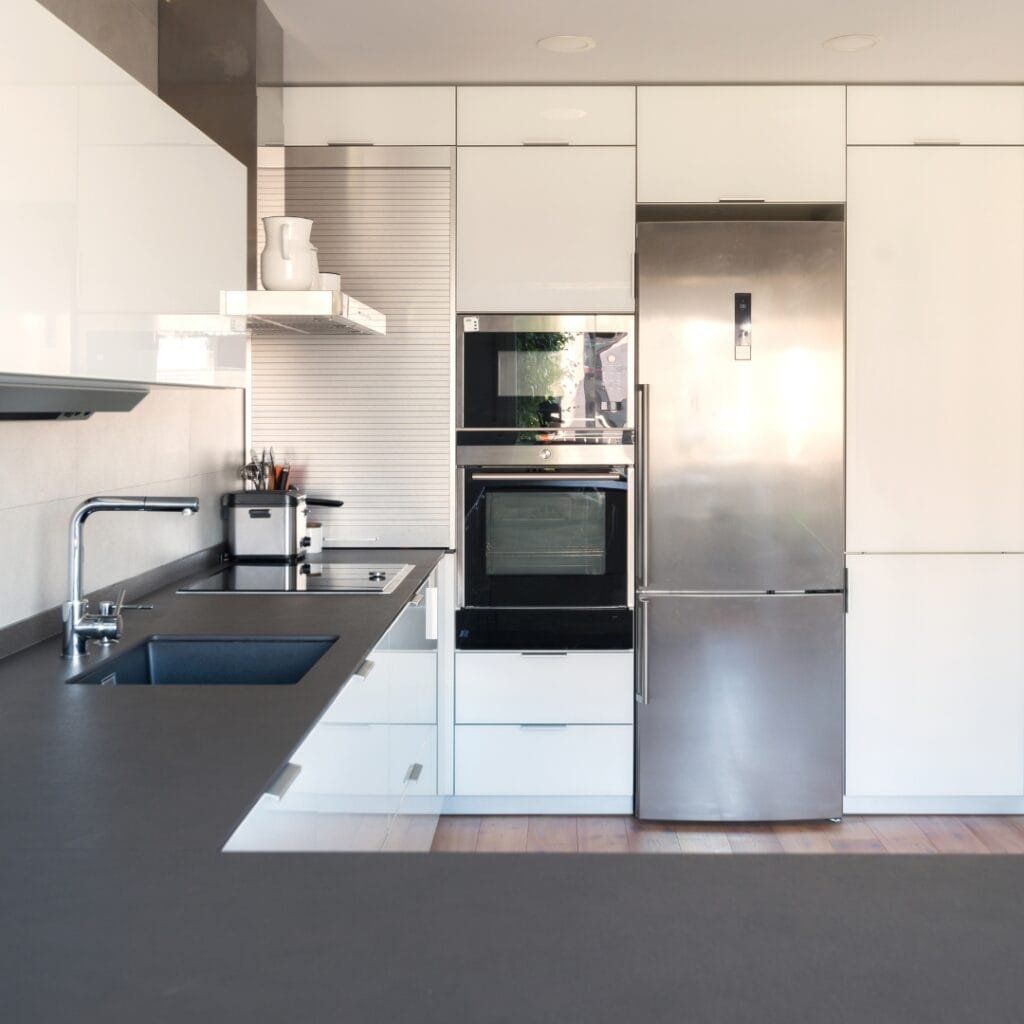 Modern kitchen with black countertop and sleek white cabinetry.