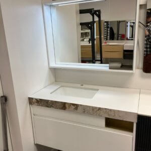 Modern 39-inch white bathroom vanity with marble countertop, integrated sink, and LED mirror in a showroom display.