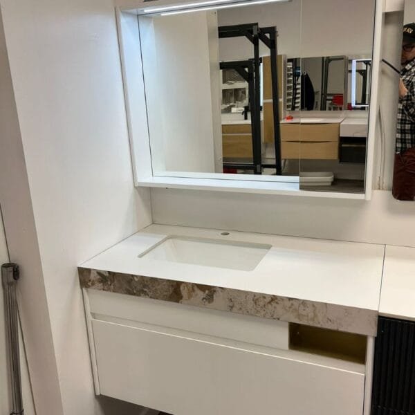 Modern 39-inch white bathroom vanity with marble countertop, integrated sink, and LED mirror in a showroom display.