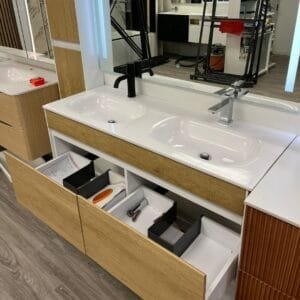 Modern floating vanity with dual sinks, open storage drawers, and a side cabinet featuring integrated LED lighting.