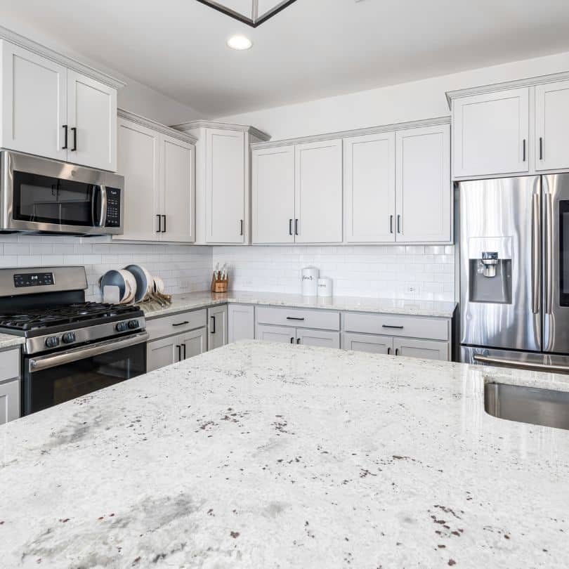 "Modern kitchen with white granite countertops and sleek cabinetry.