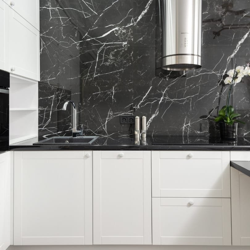 Kitchen renovation idea for North Vancouver featuring white cabinetry and a bold black marble backsplash.