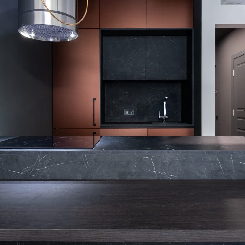 Kitchen renovation in North Vancouver BC showcasing a modern design with dark marble accents and copper cabinetry.