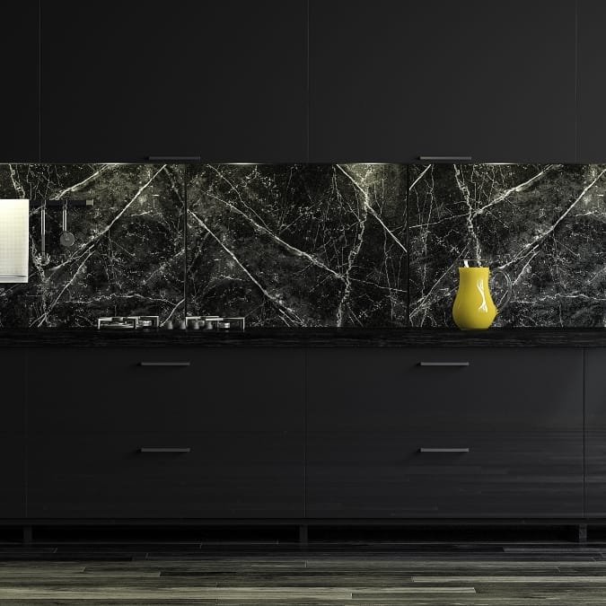 Vancouver Kitchen remodeling: Black kitchen with sleek cabinetry, dark marble backsplash, and a pop of color from a yellow vase.