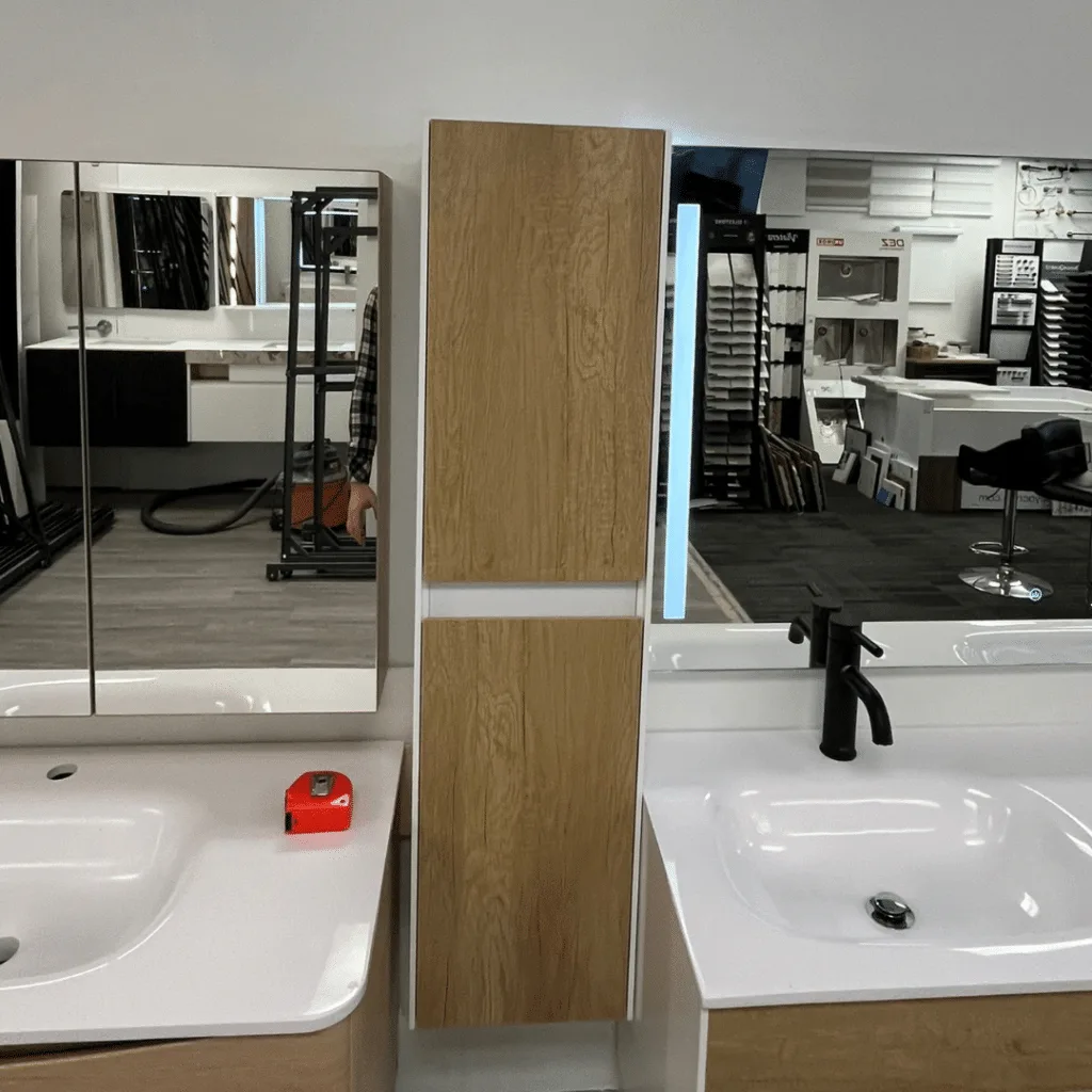 Bathroom vanity with a side cabinet, integrated LED mirror, and modern design featuring dual sinks.