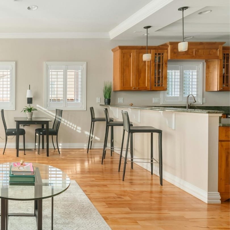 Modern Vancouver condo renovation with warm wood cabinetry, sleek bar seating, and natural light for a stylish upgrade