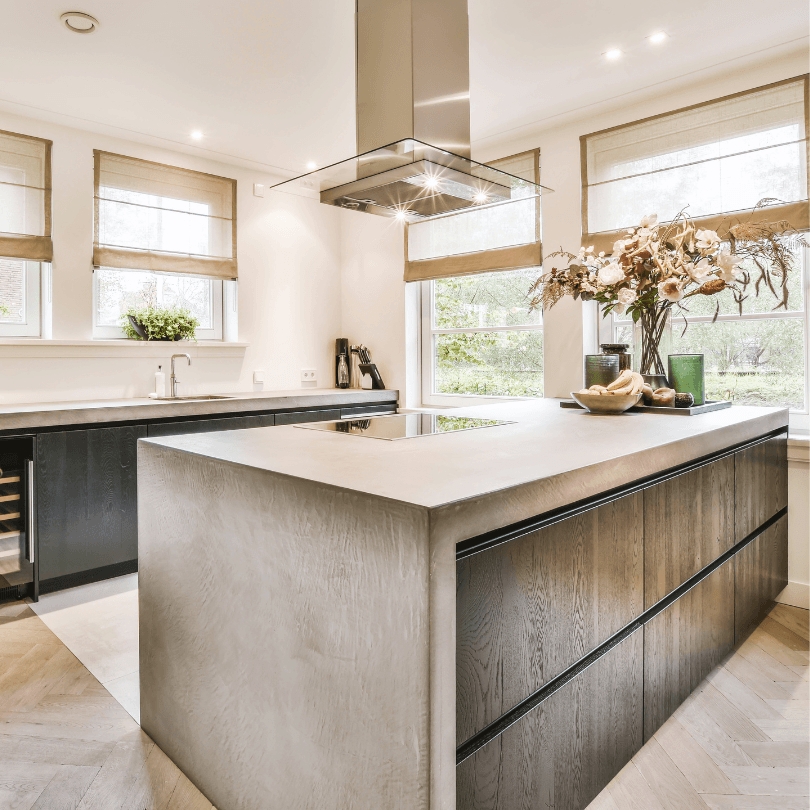 Eco-friendly kitchen renovation with sustainable materials, natural light, and modern design. Sleek concrete island and wood cabinets.