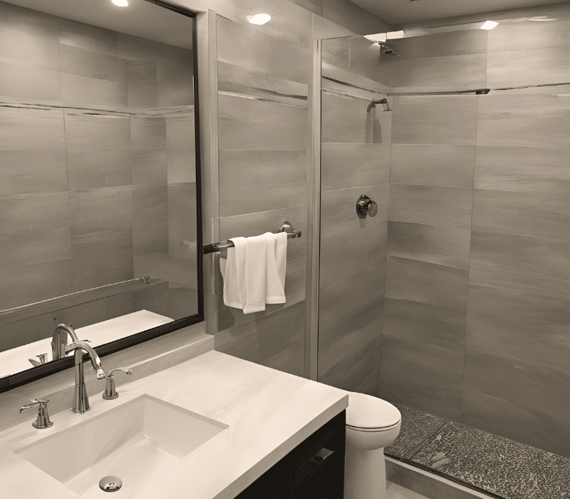 modern bathroom with a glass shower enclosure, sink, and toilet after a final inspection