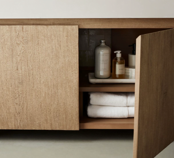 close-up of a 60-inch bathroom vanity with an open cabinet door, revealing organized storage with towels and bathroom essentials.