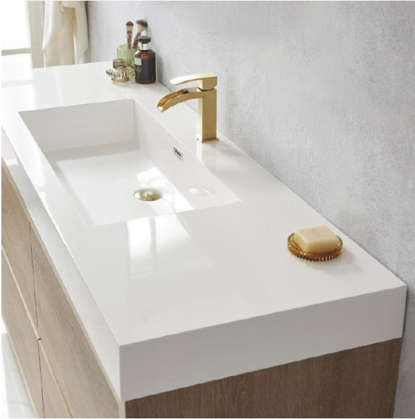 close-up of a freestanding bathroom vanity with a white countertop, integrated sink, and gold faucet.