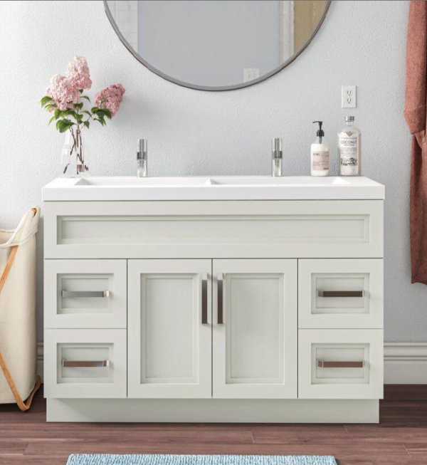 a freestanding double sink vanity with a modern design, featuring white cabinetry and sleek hardware, placed against a light-colored wall.