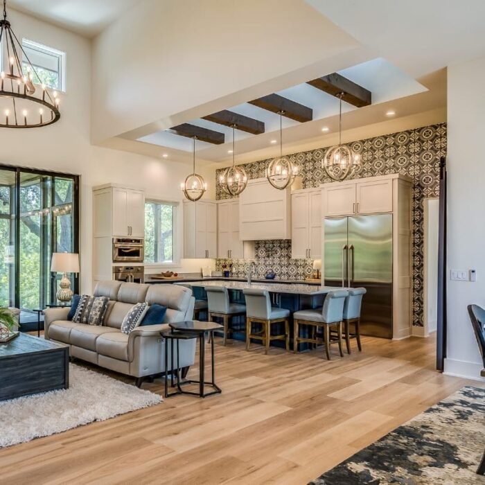 Open-concept kitchen with blue island, pendant lighting, and patterned backsplash. Modern kitchen renovation ideas.